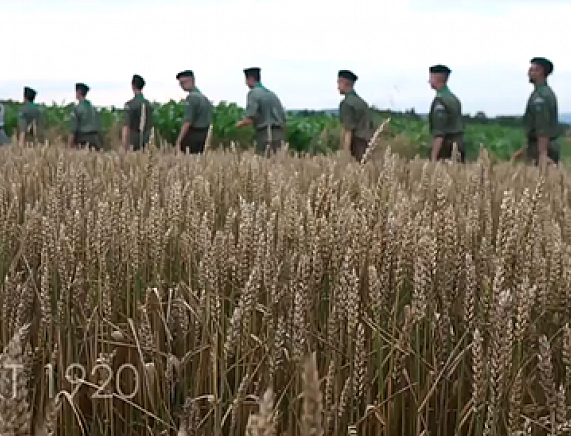 Kadr teledysku 1920 - harcerze maszerujący wśród pól