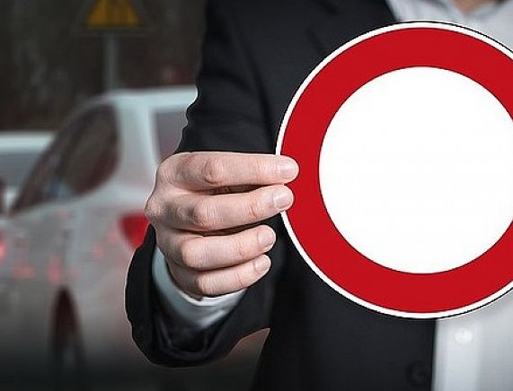 Znak zakazu trzymany w dłoniach