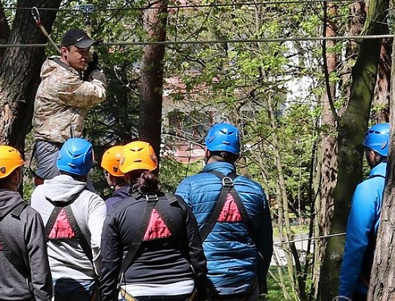 Instruktor w parku linowym tłumaczygrupie zasady korzystania z urządzeń
