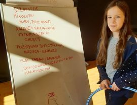 dziewczynka stojąca przy tablicy,na której rozpisała pomysły co może sie zadziać w klubie mama i ja