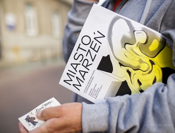 Folder Miasto marzeń niesiony pod pachą