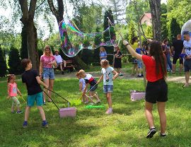 dzieci uczą się puszczać ogromnr bańki mydlane