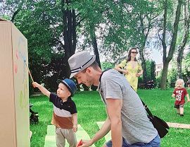 chłopiec maluje duże kartonowe pudełko