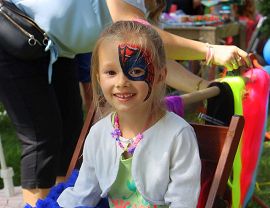 uśmiechnięta dziewczynka z pomalowaną twarzą