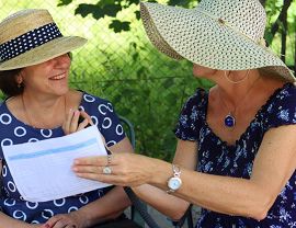 dwie uśmiechnięte panie siedzą na ławce i rozmawiają ze sobą