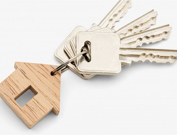 drewniany breloczek w kształcei domu z kluczami od mieszkania
