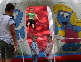 dzieci zjeżdżają na dmuchanej zjeżdżalni