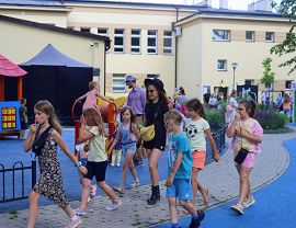 dzieci przechadadzają się obok placu zabaw