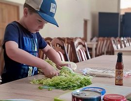 chłopiec kroi kapustę pekińską