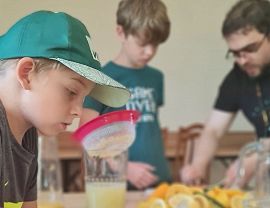 chłopcy z panem Adamem przygotowują cytryny na lemoniadę