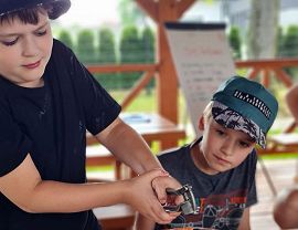 dzieci wyciskają czosnek do sosu pomidorowego