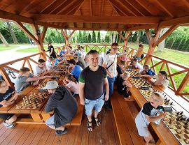 Pan marcin zięba między stołami przy których rozgrywane są partie szachowe