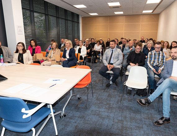 Zdjęcie przedstawia uczestników prac warsztatowych w sali konferencyjnej.