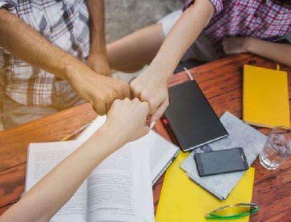 youngsters-stacking-hands-with-determination.jpg