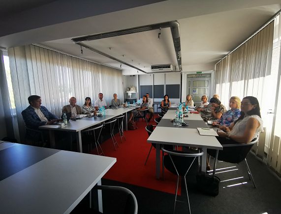 Spotkanie robocze w ramach Miejskiego Obszaru Funkcjonalnego Krosno. Zdjęcie przedstawia osoby obradujące w sali konferencyjnej.