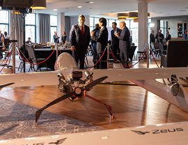 Na pierwszym planie dron, w tle rozmowy, networking.