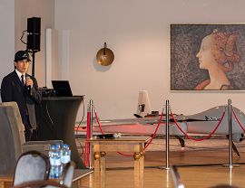 Prezes firmy Ekolot Aerospace&Defense podczas prezentacji. W tle dron.